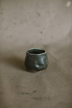 Load image into Gallery viewer, A small dark black blue wood fired cup on a beige fabric background. This wheel thrown and altered Japanese inspired yunomi is made from dark speckled Australian stoneware clay that has a Cobalt blue glaze that has been reduction fired in a wood kiln