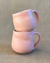Load image into Gallery viewer, Two pink ceramic mugs stacked on a textured surface with a blurred background