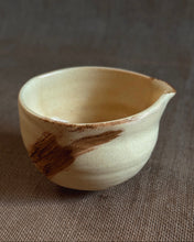 Load image into Gallery viewer, Yellow ceramic matcha bowl with brown accents on a textured brown surface