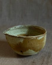 Load image into Gallery viewer, Ceramic matcha bowl with pale green and gold glaze on a textured fabric background