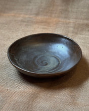 Load image into Gallery viewer, Ceramic pasta bowl with a metallic black glaze sitting on a textured beige surface