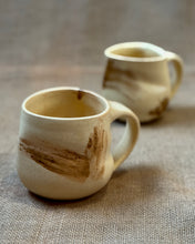 Load image into Gallery viewer, Two yellow glazed ceramic mugs with brown accents on a textured surface